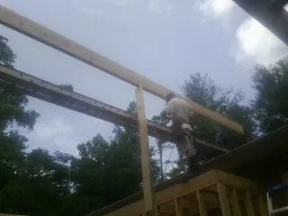 Carpenter setting a ridge beam over a new addition frame — Ice Dam Removal by Roofing Brothers in Henefer