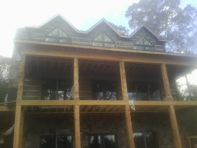 Dormers and porch framing on a large log home under construction — Roof Coating work by our crew in Henefer