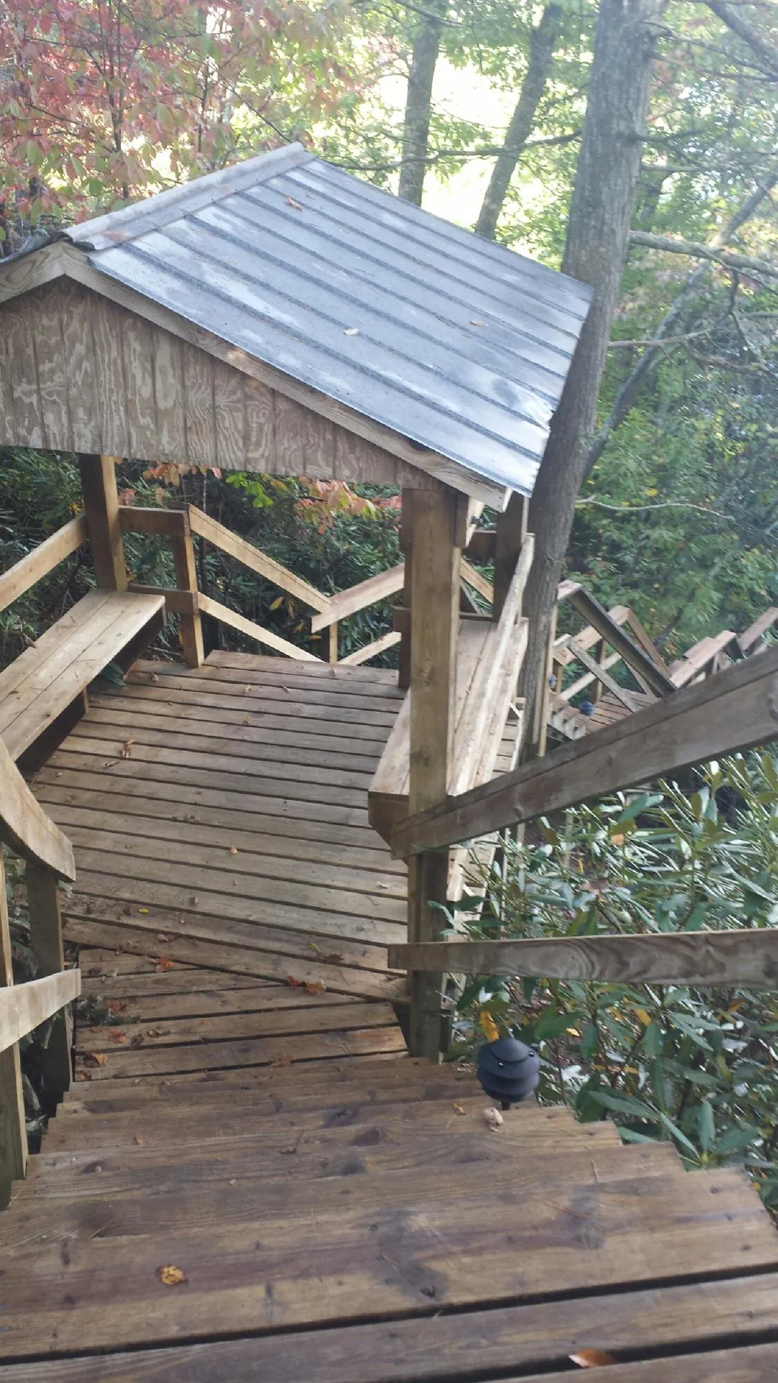 Metal roofed shelter over wooden steps on a wooded walkway — Skylight Repair & Installation work by our crew in Henefer