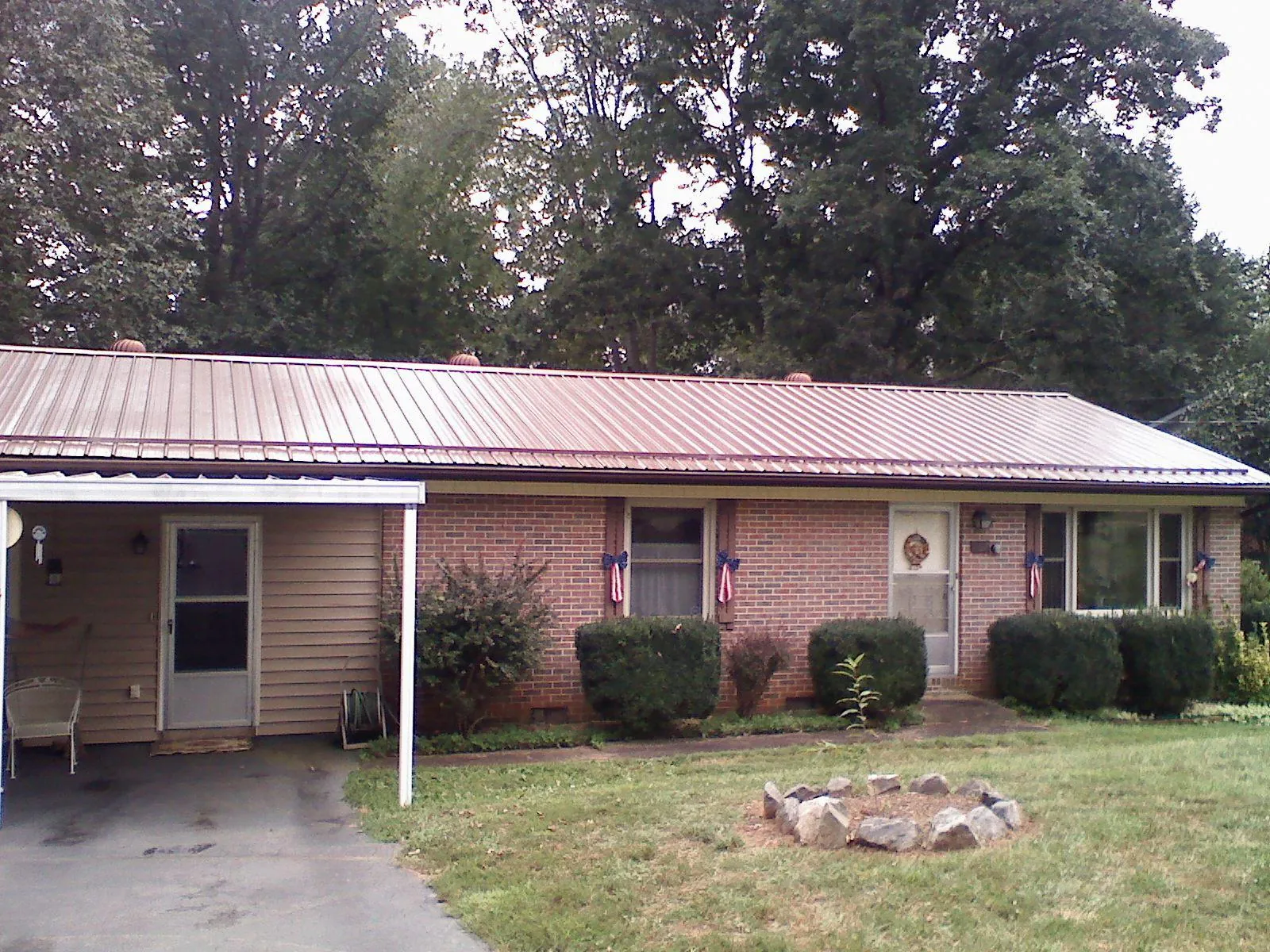 Bronze metal roof and carport on a brick ranch home — Roof Repair work by our crew in Henefer